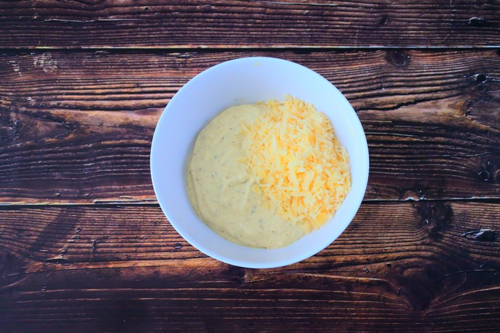 An overhead image of a bowl of Caesar Salad Dressing with Parmesan cheese on top