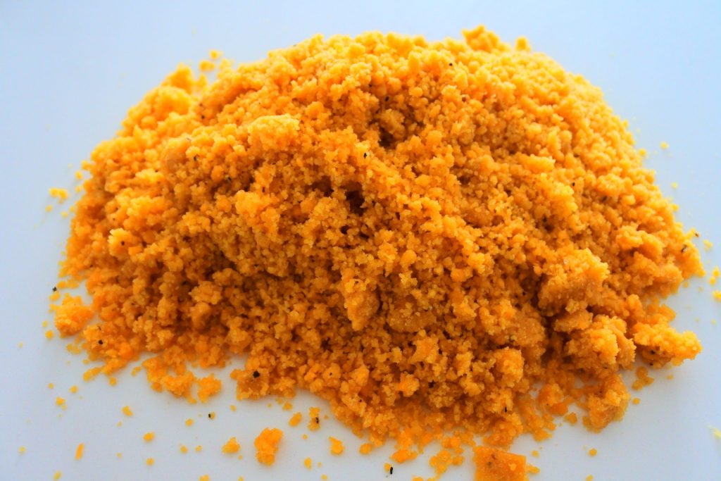 A close up image of cracker dough in a crumbly state before being squeezed and worked together into a dough.