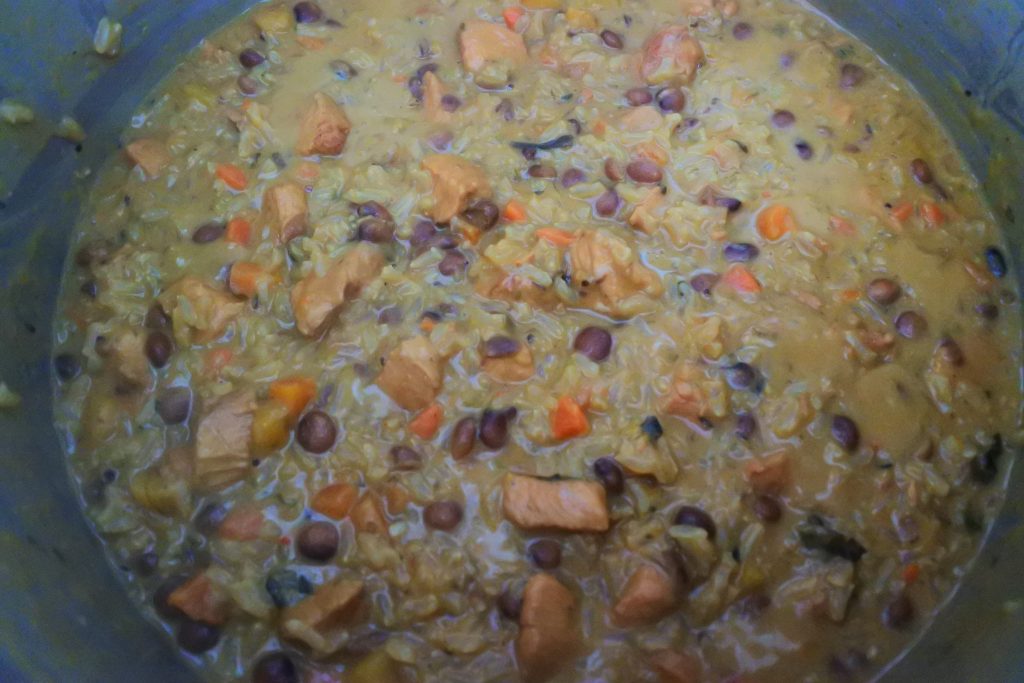An overhead image of a pot of simmering pelau