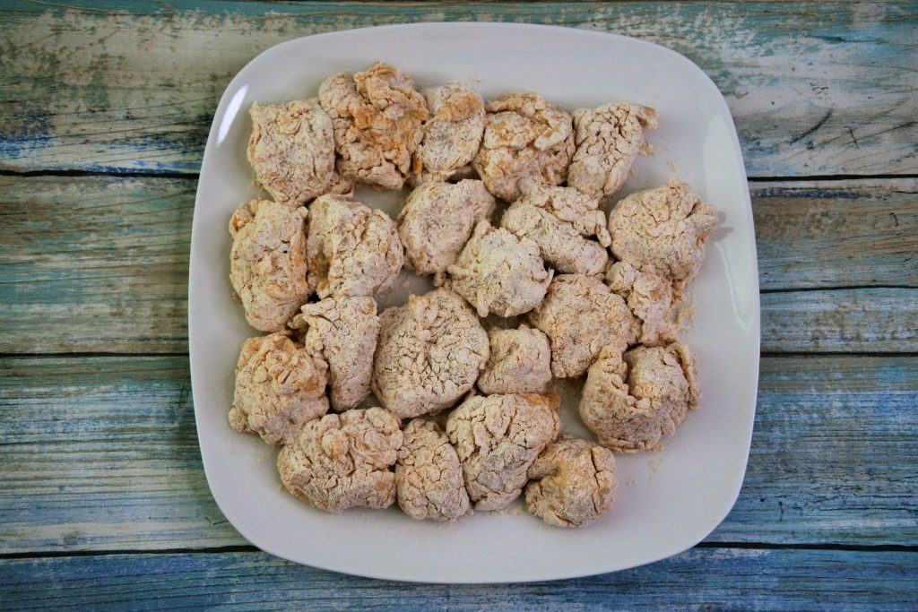 An overhead image of a plate of breaded popcorn chicken pieces