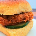 A close up image of a copy cat Chick-fil-A original sandwich with a homemade pickle on a Hawaiian dinner roll