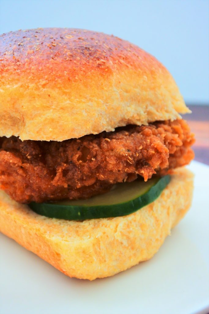 A close up image of a copy cat Chick-fil-A original sandwich with a homemade pickle on a Hawaiian dinner roll