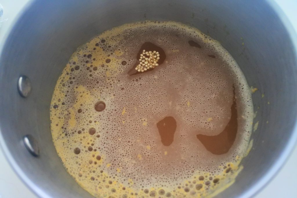 An overhead image of a pot containing quinoa and broth bring cooked together