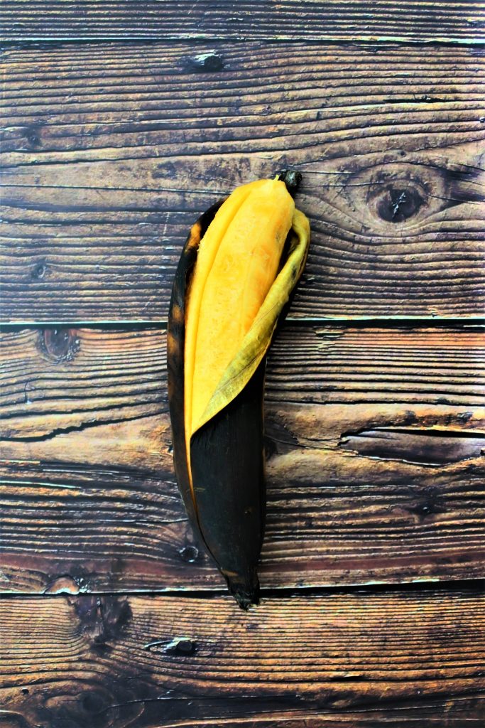 An overhead image of a partially peeled whole ripe plantain