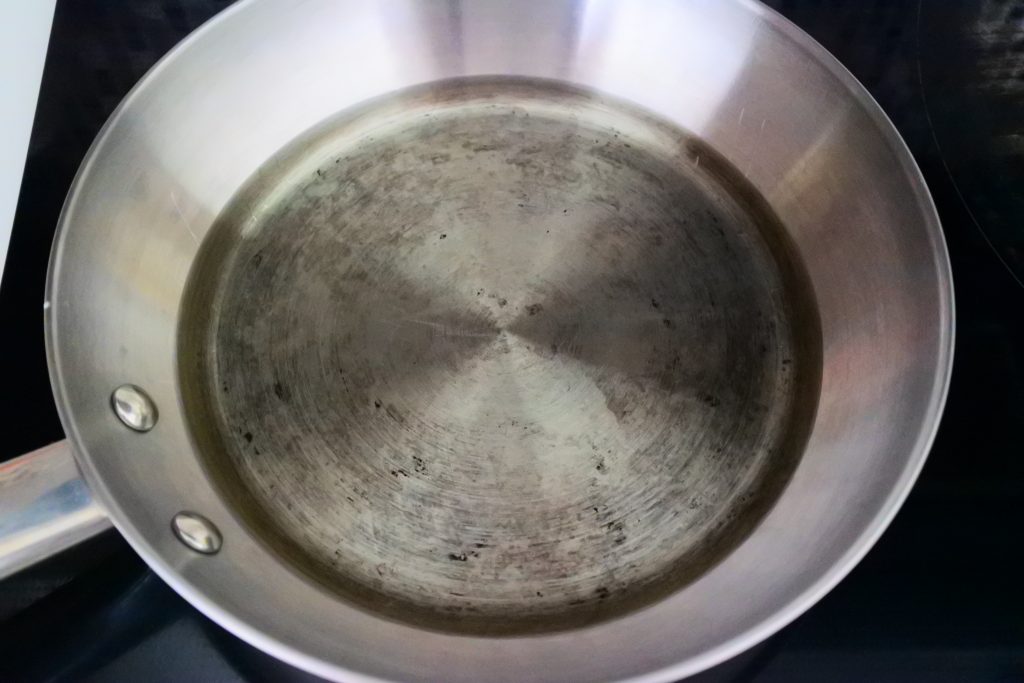 An angled overhead image of a frying pan with a half inch of oil.