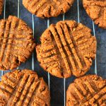 An overhead image of peanut butter cookies on a wire cooling rack