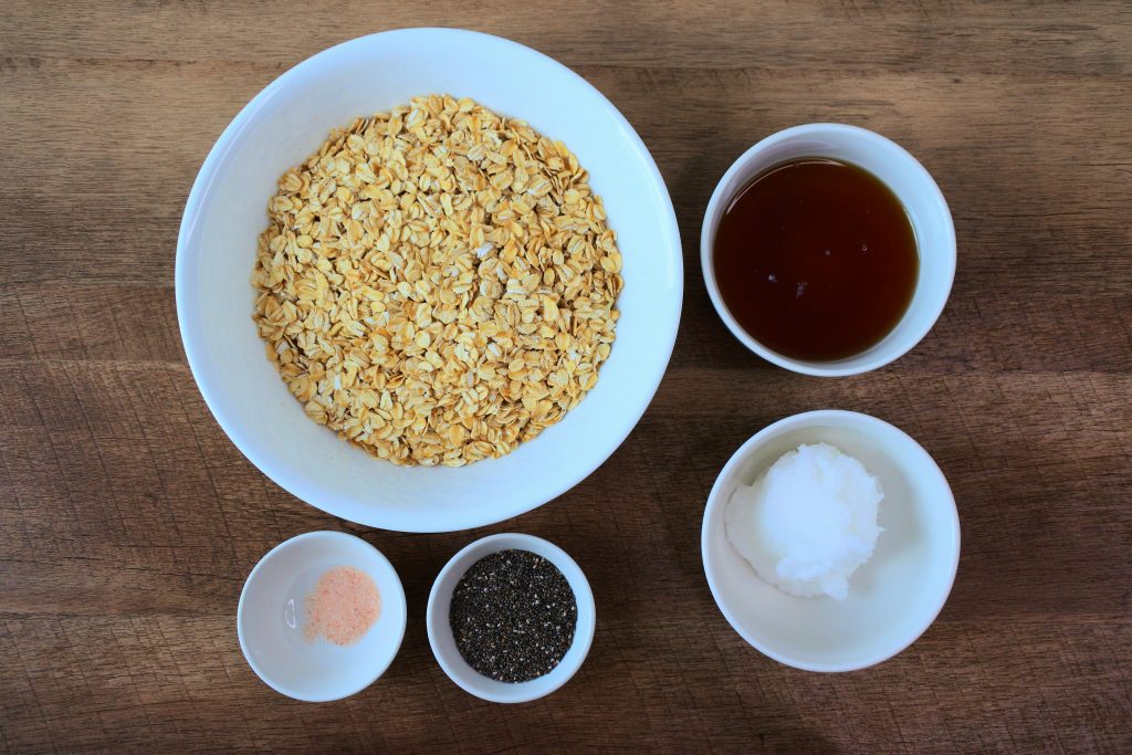 Overhead image of bowl of ingredients including: old-fashioned rolled oats, maple syrup, coconut oil, salt and chia seeds.