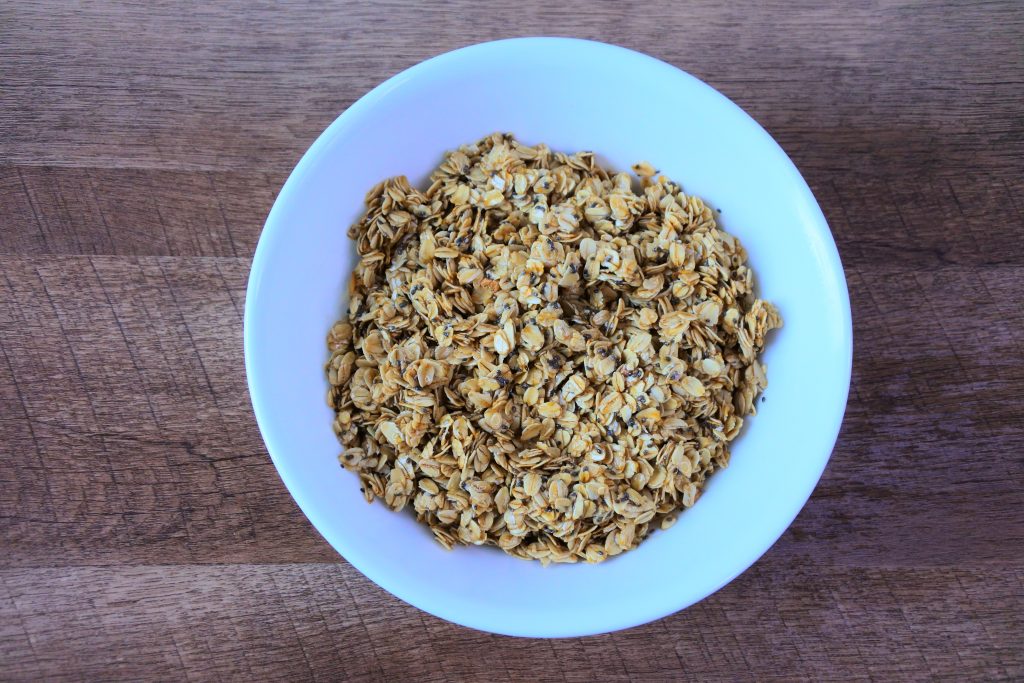 An overhead image of a bowl of old-fashioned rolled oats mixed with maple syrup, coconut oil, salt and chia seeds