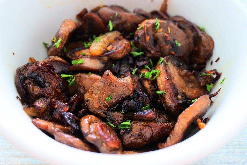A close up image of caramelized onion and mushrooms in a bowl