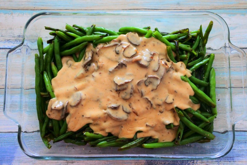 An overhead image of blistered green beans with a mushroom sauce poured over it