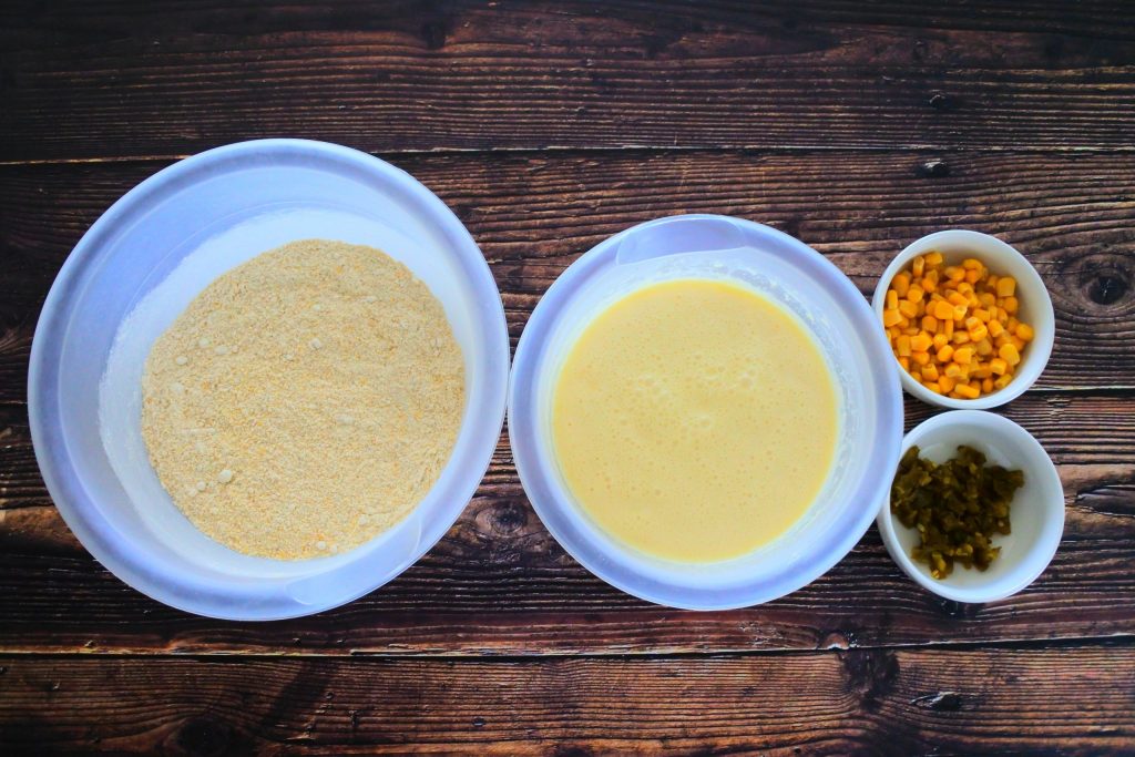And overhead image of bowls containing wet ingredients, dry ingredients and two smaller bowls of sweet corn kernels and diced jalapenos