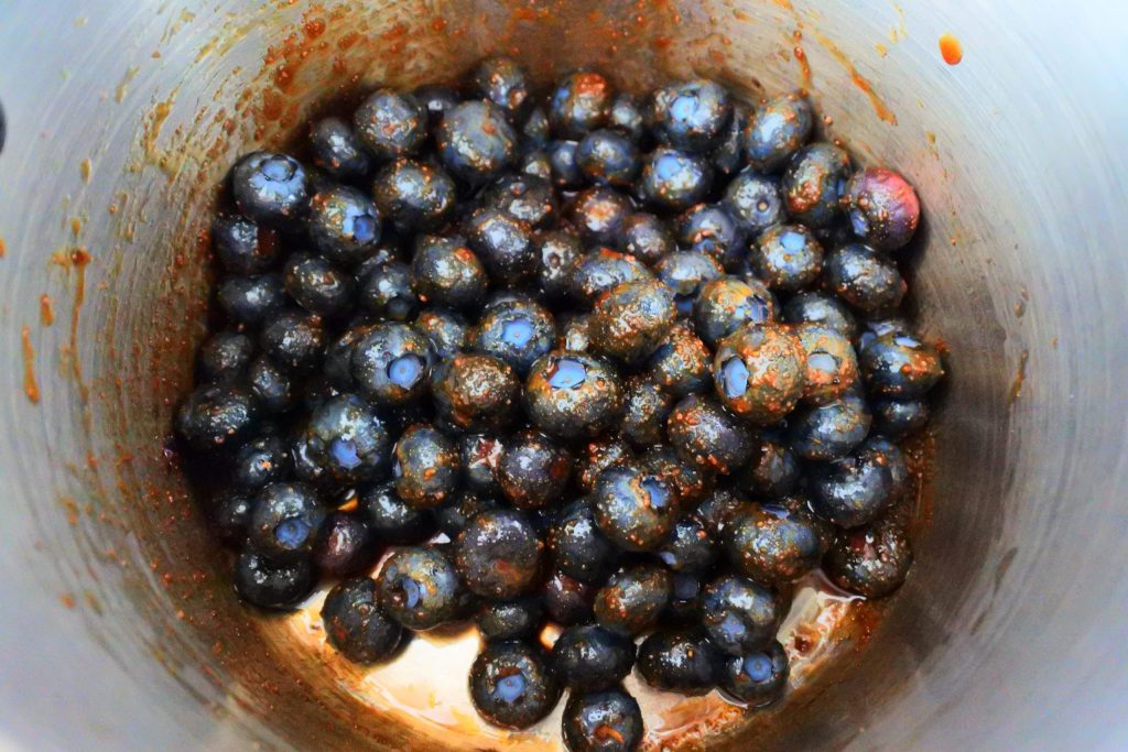 An overhead image of a pot of coconut sugar coated blueberries