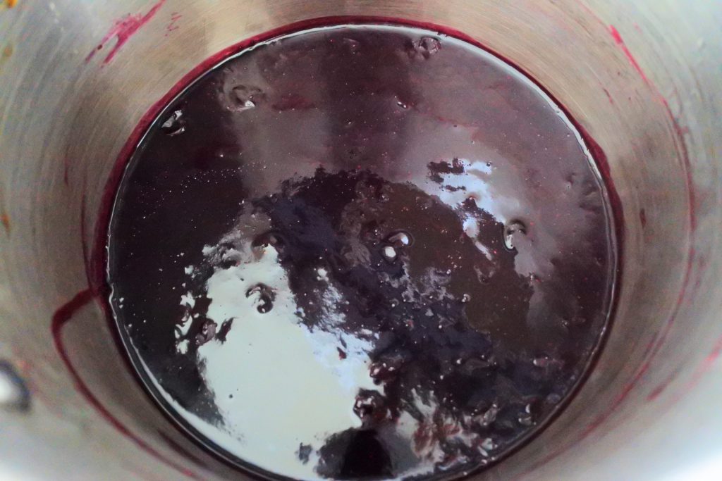 An angled image of blueberry jam in a pot