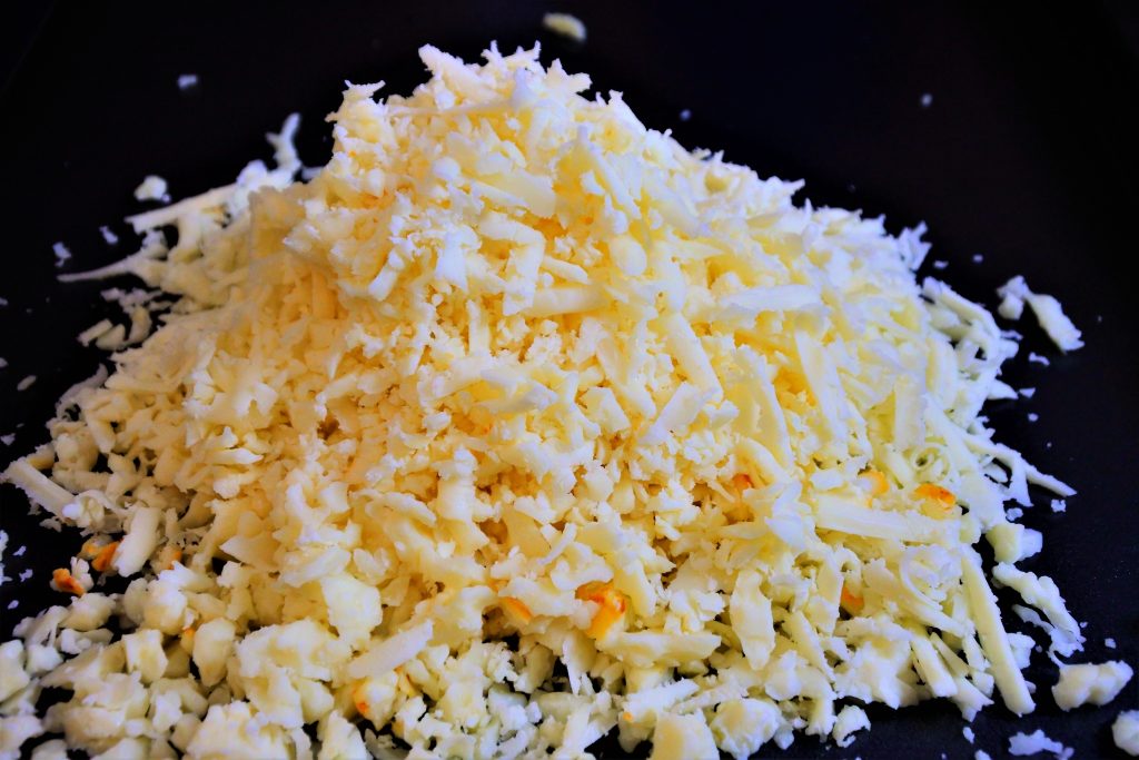 A head on close up image of a pile of shredded cheese