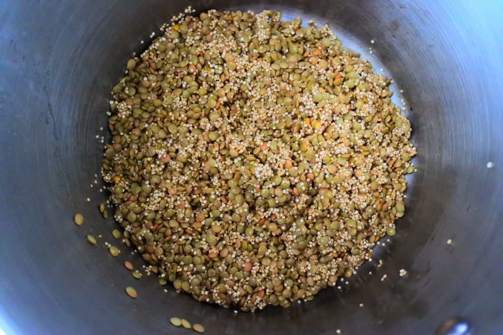 An overhead image of a pot of uncooked lentils and quinoa mixed together