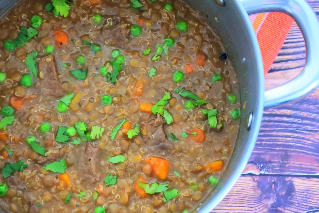 A close up overhead image of a pot of lentil, quinoa and beef stew