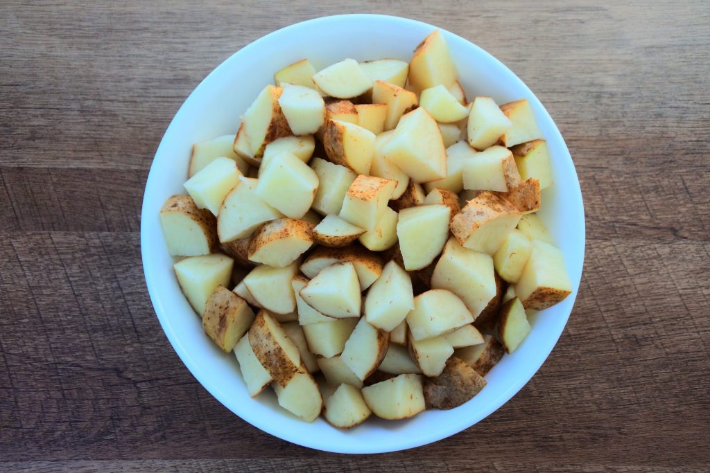An overhead bowl of diced potatoes