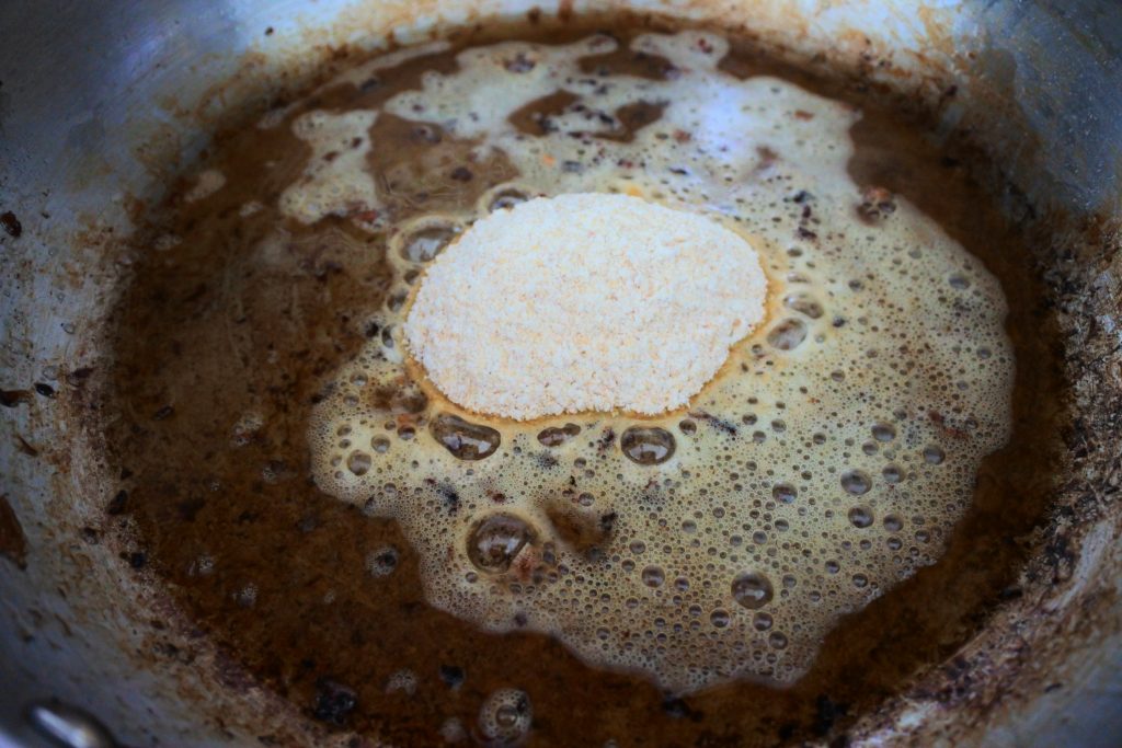 A close up image of melted butter in a fond with whole wheat pastry flour (aka the roux base for our gravy)