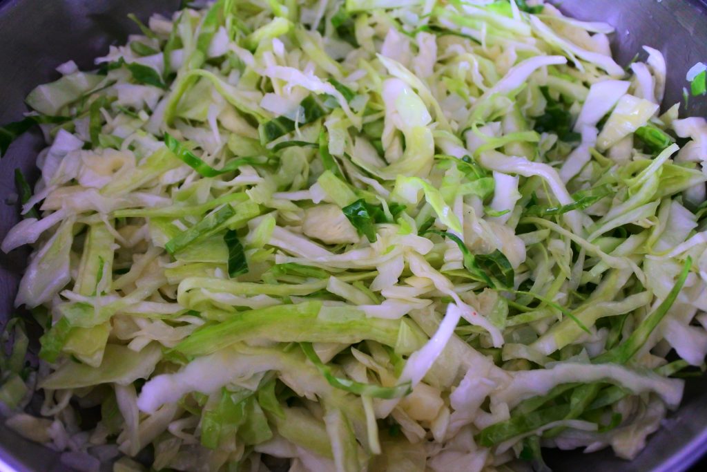 An close up angled image of cabbage being cooked in a skillet