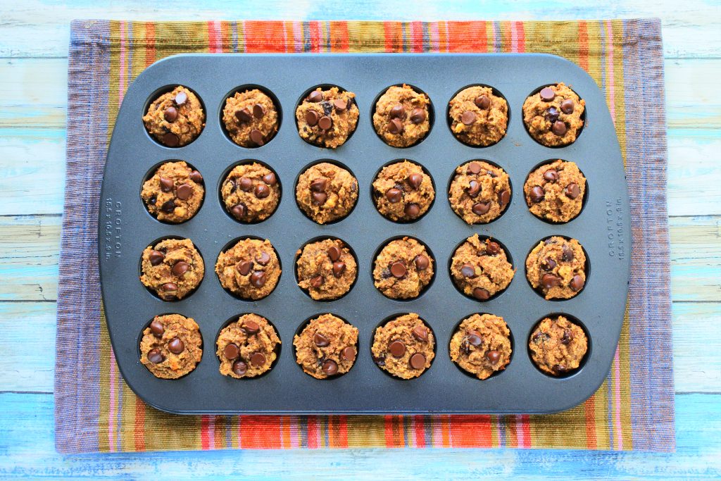 An overhead image of a mini muffin tray of baked banana nut dark chocolate muffins