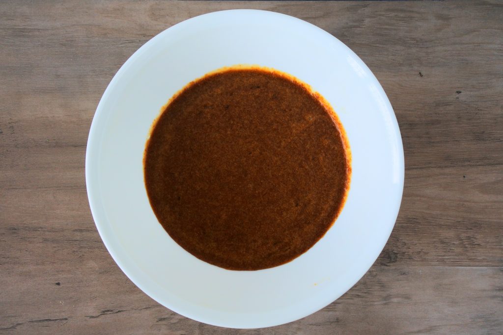 An overhead image of a bowl containing a mixture of melted butter, coconut sugar, vanilla, and eggs.