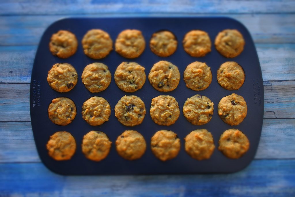 An overhead image of a mini muffin tray of baked chocolate chip mini muffins