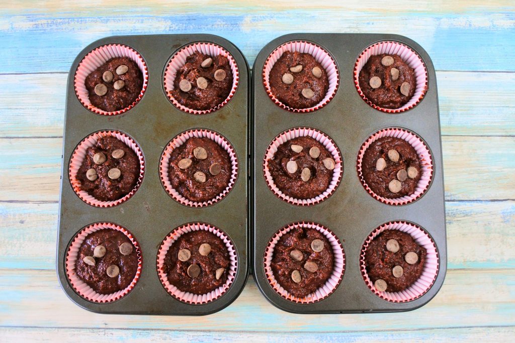An overhead image of two six-count muffin tins side by side with unbaked Gluten Free Double Chocolate Chip muffins in them