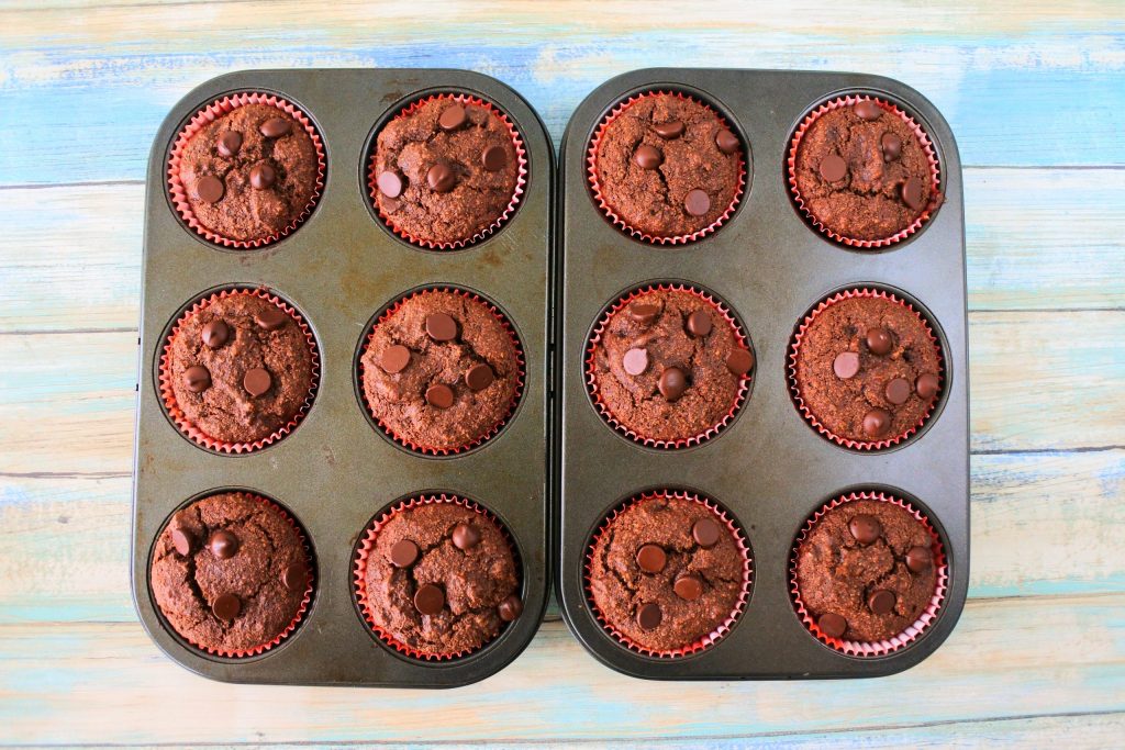 An overhead image of two six-count muffin tins side by side with baked Gluten Free Double Chocolate Chip muffins in them