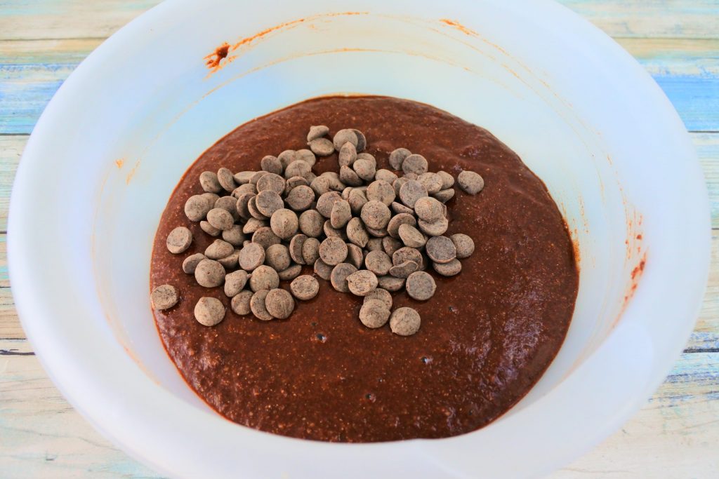 An angled image of a bowl of Gluten Free Double Chocolate Chip muffin batter with chocolate chips on top