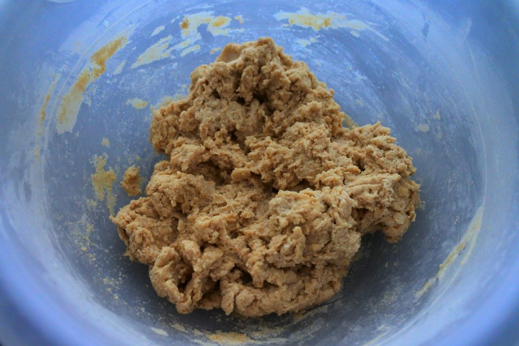 An overhead image of unkneaded naan dough in a bowl