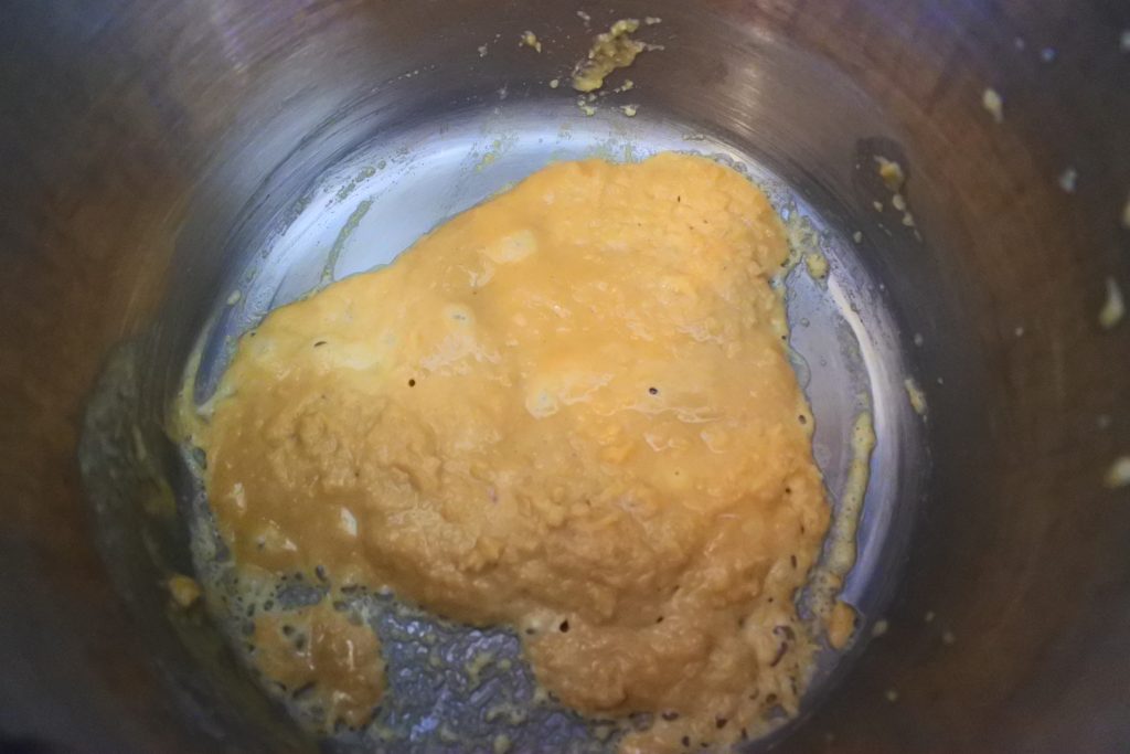 An overhead image of melted butter and flour for a roux in a pot