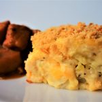 A close up image of a piece of green banana pie paired with some Caribbean-style stew chicken