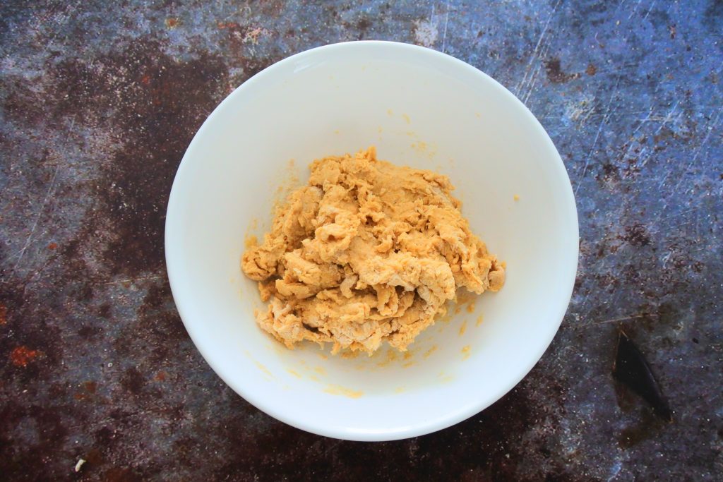 An overhead image of unkneaded dough in a bowl