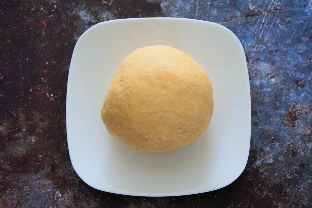 An overhead image of a plate with a large dough ball