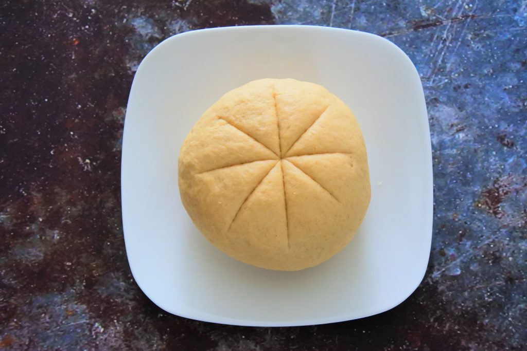An overhead image of plate with dough with knife division markings