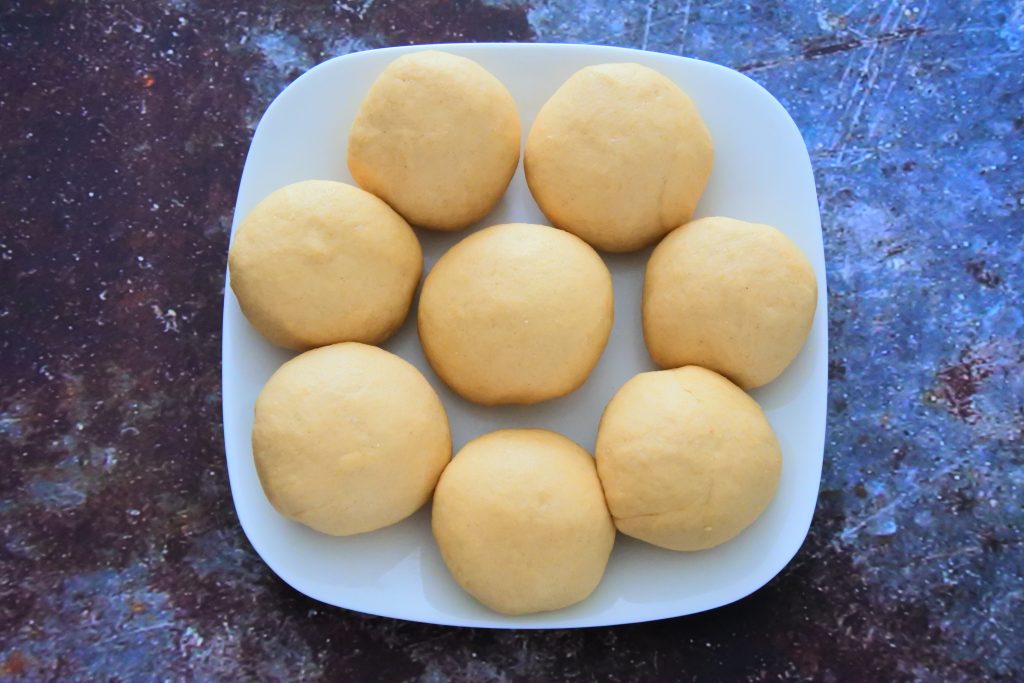 An overhead image of a plate with eight equally rolled out portions of dough