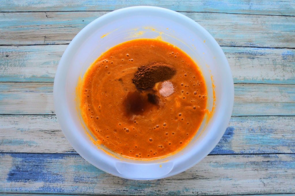 An overhead image of spices being added into the batter for pumpkin spiced bread.