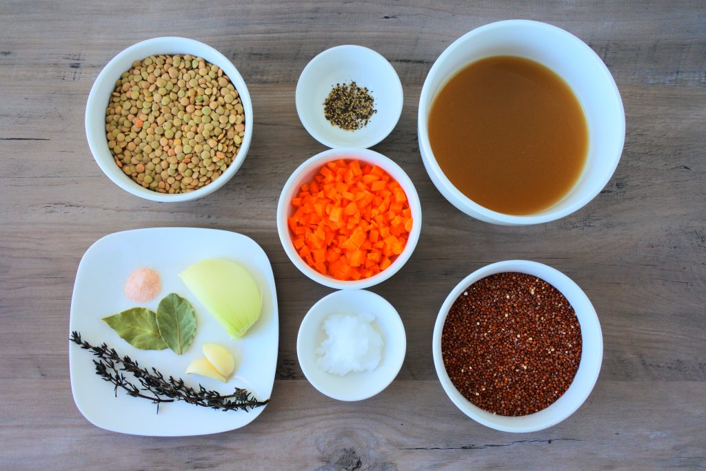 An overhead image of dishes containing the following ingredients for a lentil and quinoa pilaf: lentils, salt, bay leaves, onion, garlic, fine thyme, black pepper, coconut oil, diced carrots, broth and quinoa