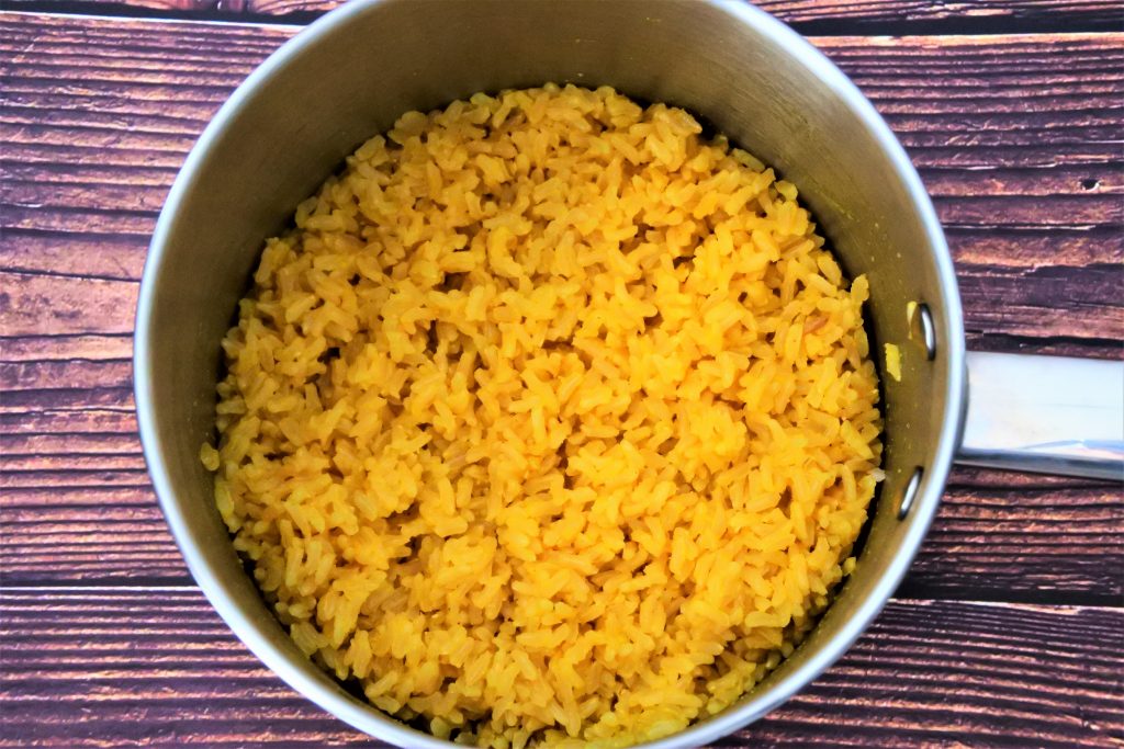 An overhead image of a pot containing coconut saffron rice.