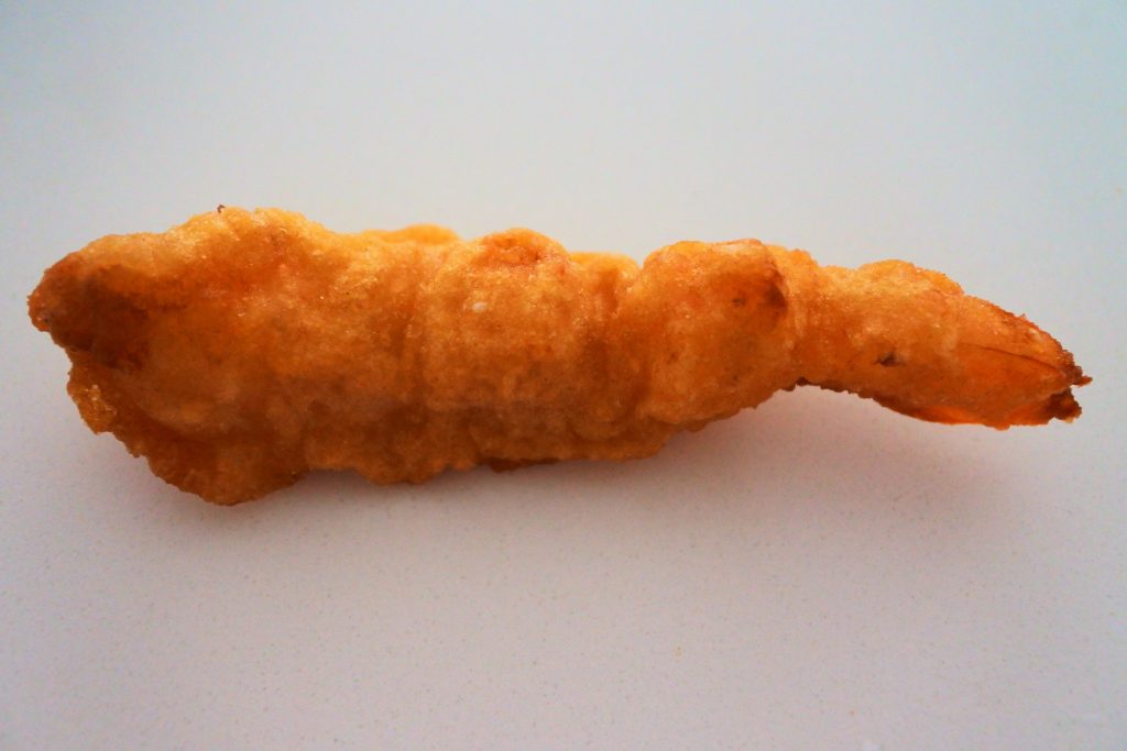 A close up, head on image of a golden fried shrimp tempura