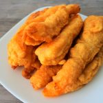 A tilt-towards image of a plate of golden fried shrimp tempura