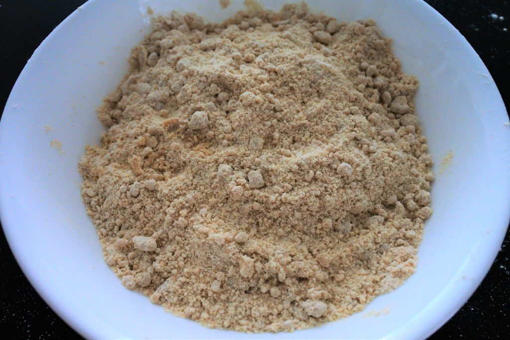 An overhead image of a bowl of whole wheat flour cut with olive oil