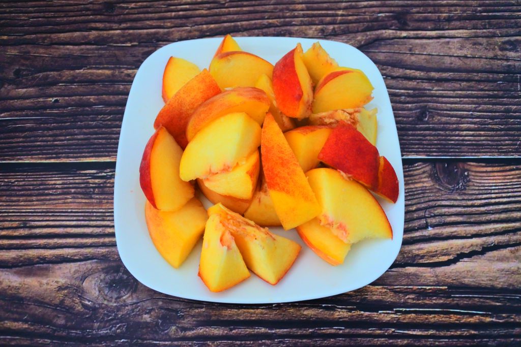 An angled image of a plate of fresh peach pieces