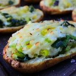 A close up image of twice baked potatoes with leeks